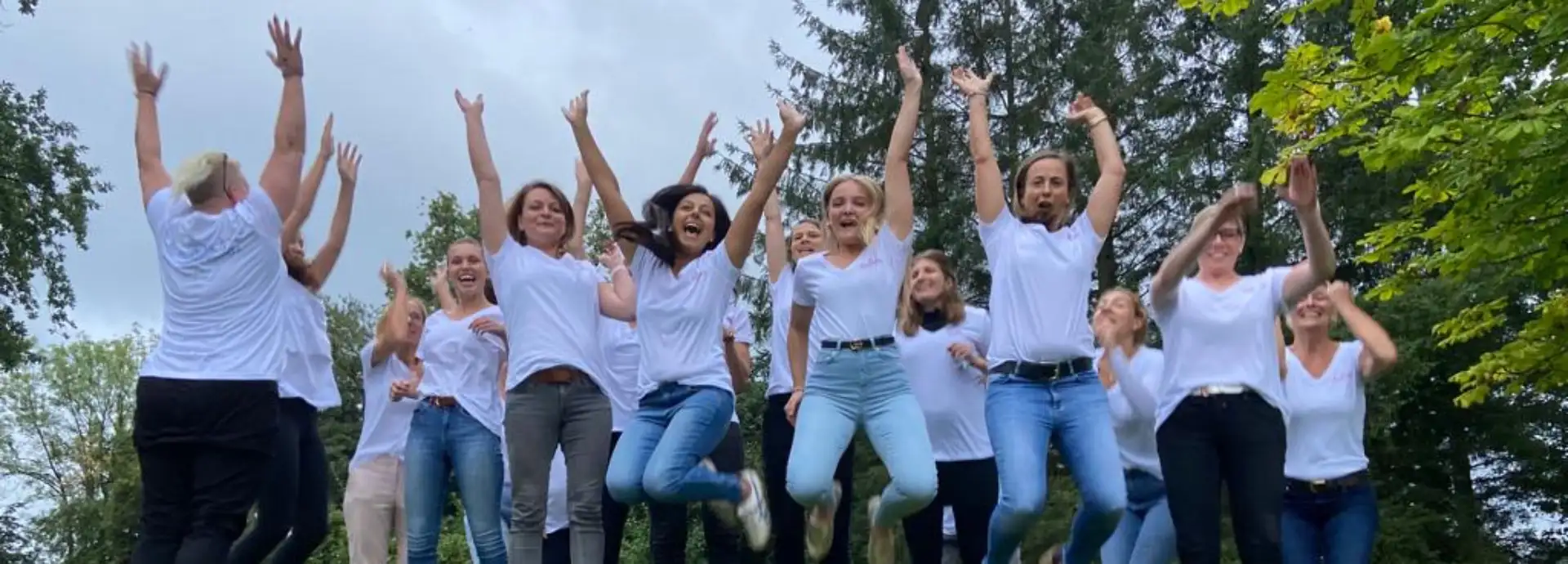 Kidsanker team und ehrenamtliche im garten am hochspringen